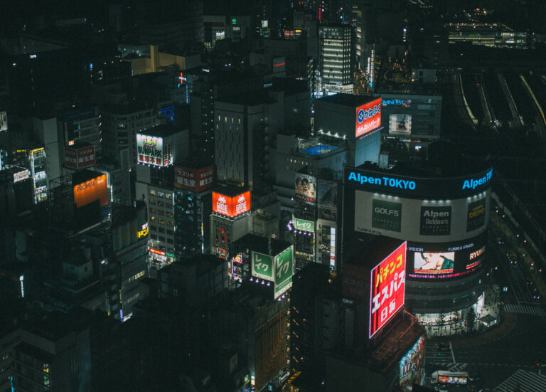 moody, edited view of tokyo’s shinjuku skyline from the groove hotel, featuring city lights, popular spots, and towering buildings
